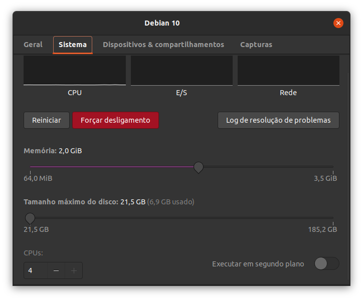 Exibindo a janela adicional do menu propriedades com as abas superiores Geral, Sistema, Dispositivos e compartilhamentos e Capturas. A aba Sistema está selecionada. Logo abaixo há as informações sobre a CPU, E/S e Rede, alinhadas horizontalmente. Logo abaixo há três botões alinhados horizontalmente (Reiniciar, Forçar desligamento e Log de resolução de problemas). Mais abaixo há dois botões deslizantes alinhados verticalmente para alterar o valor da memória e o tamanho do disco, respectivamente. No rodapé, à esquerda, há um campo para alterar a quantidade de CPUs utilizadas (campo numérico, botões com sinais de subtração e soma), e à direita, uma caixa de checagem para habilitar a execução em segundo plano.