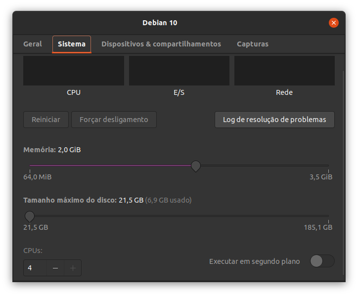 Exibindo a janela adicional do menu propriedades com as abas superiores Geral, Sistema, Dispositivos e compartilhamentos e Capturas. A aba Sistema está selecionada. Logo abaixo há as informações sobre a CPU, E/S e Rede, alinhadas horizontalmente. Logo abaixo há três botões alinhados horizontalmente (Reiniciar (desabilitado), Forçar desligamento (desabilitado) e Log de resolução de problemas). Mais abaixo há dois botões deslizantes alinhados verticalmente para alterar o valor da memória e o tamanho do disco, respectivamente. No rodapé, à esquerda, há um campo para alterar a quantidade de CPUs utilizadas (campo numérico, botões com sinais de subtração e soma), e à direita, uma caixa de checagem para habilitar a execução em segundo plano.